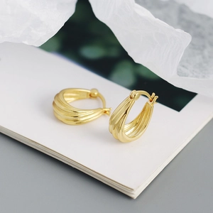 Macro detail of gold S925 silver hoop earrings with unique triple ridge ripple texture