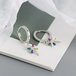 Detalle macro de pendientes de aro de plata 925 con colgante de estrella de circonitas