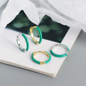 Détail de créoles en émail vert émeraude avec argent s925 et or sur papier blanc