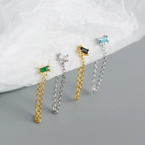 Detail of s925 silver chain fringe earrings set with emerald and zircon stones