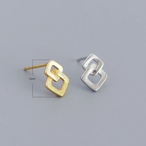 Detail van 12 mm geometrische vierkante in elkaar grijpende oorknopjes in goud en zilver