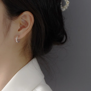 Close-up of S925 sterling silver geometric chain link hoop earrings on model ear