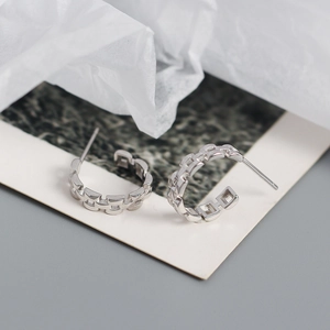 Detail of silver S925 geometric chain link C-shaped stud earrings with polished finish