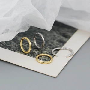 Close-up of S925 sterling silver geometric hoop earrings in gold and silver finishes