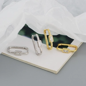 Detailed macro of gold and silver S925 earrings with rectangular cubic zirconia stones