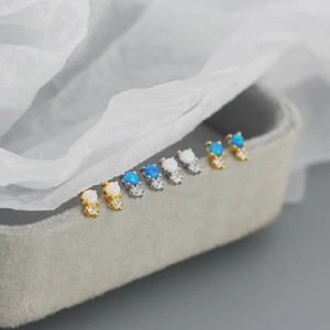 Macro detail of minimalist S925 silver opal stud earrings with cubic zirconia on velvet tray