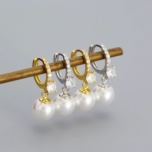 Dettaglio di orecchini di perle in argento s925 con zirconi brillanti in oro e argento
