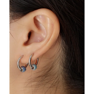 Macro shot of S925 silver hoop earrings featuring blue pave-set rotating beads on model