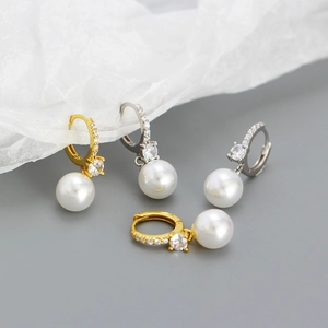 Dettaglio di eleganti orecchini con perle e zirconi incastonati in finitura oro e argento