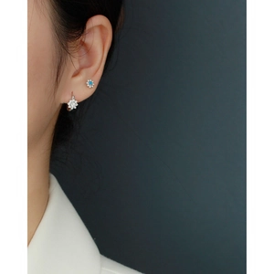 Detail of floral S925 silver stud earrings with blue opal and white crystals on ear