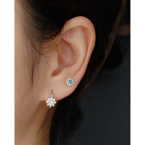 Gros plan de boucles d'oreilles fleur en argent S925 avec pierres bleues et cristaux