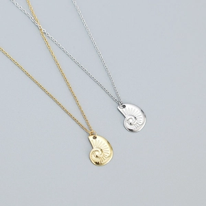 S925 sterling silver ocean conch necklace set in gold and silver finish on a grey background