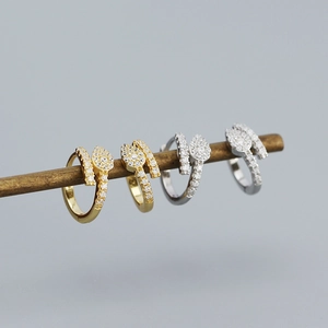 Dettaglio di orecchini a serpente in argento e oro con pietre di zircone