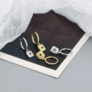 Detail of gold and silver S925 sterling silver starburst hoop earrings with black zircon