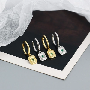Detail of vintage gold and silver hoop earrings with starburst green stone pendants