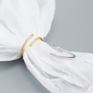 Macro shot of minimalist gold and silver S925 adjustable rings with pavé cubic zirconia