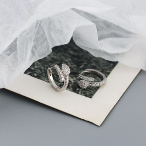 Macro di orecchini a serpente in argento con zirconi incastonati su carta artistica