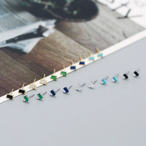 Macro detail of geometric rectangular zircon earrings in multiple colors and silver plating
