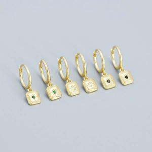 Minimalist gold starburst hoop earrings featuring emerald and clear gemstone pendants
