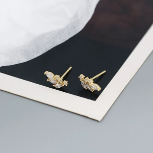 Detailed close-up showing S925 hallmark on gold leaf stud earrings with white zircons