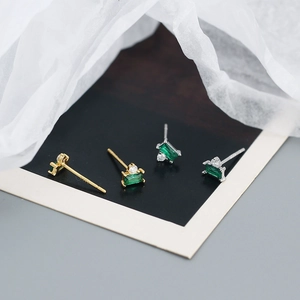 Close-up of S925 silver stud earrings with emerald green rectangular zircon stones