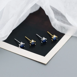 Detail of s925 silver stud earrings with blue rectangular zircons in gold and silver