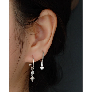 Detail view of silver S925 C-shaped hoop earrings with tassel crystal drops on ear