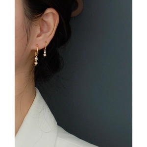 Detail view of S925 silver C-shape tassel earrings with gold finish and zircon stones