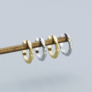 Detail of s925 silver ear cuffs with irregular hammered texture in gold and silver
