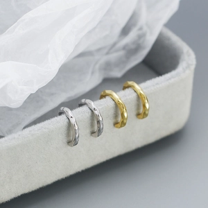 Detail of s925 silver ear cuffs with irregular hammered texture in gold and silver