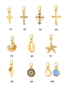 Collection of ten gold-plated nautical charms including shells, stars and crosses