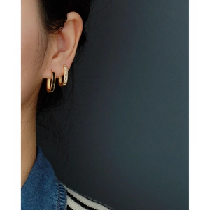 Close-up of S925 silver U-shaped earrings with gold plating and cubic zirconia inlay