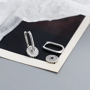 Gros plan sur boucles d'oreilles en U en argent S925 avec pendentifs en zircon et engrenage
