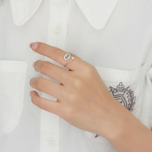 Detail of s925 silver devil eye open ring with blue and white zircon stones on model