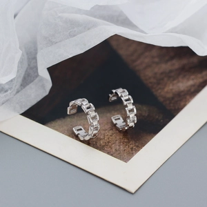 Macro shot of S925 sterling silver ear cuffs featuring a polished chain link watchband design