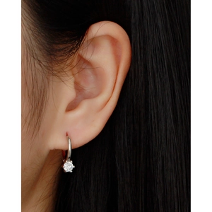 Close-up of S925 sterling silver hoop earring with sparkling zircon pendant on model