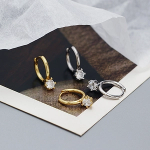Macro shot of gold and silver S925 sterling silver huggie earrings with round cubic zirconia