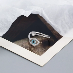 Macro shot of silver Evil Eye open ring with zircon inlay on decorative display card
