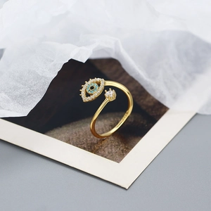 Close-up of gold S925 silver evil eye open ring with blue stone and sparkling zircons