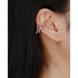 Dettaglio di ear cuff in argento s925 con nappe di zirconi lucenti sull'orecchio della modella