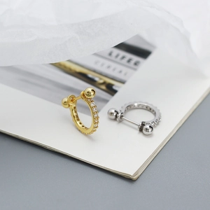 Detail of gold and silver S925 sterling silver cartilage earrings with tiny zircons