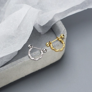 Détail macro de boucles d'oreilles vagues en argent S925 avec fermoir à bille vissée