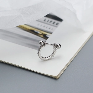 Close-up of S925 silver piercing stud with pavé zircon and minimalist dual bead design