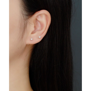 Close-up of minimalist 4mm pearl stud earrings in S925 silver on woman's ear