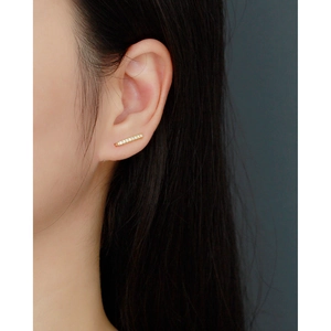 Gros plan d'un clou d'oreille en argent s925 doré avec zircons sur le mannequin