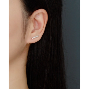 Détail macro de boucles d'oreilles en argent S925 avec zircons brillants sur l'oreille