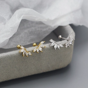Macro view of gold and silver S925 stud earrings with marquise zircon fan clusters
