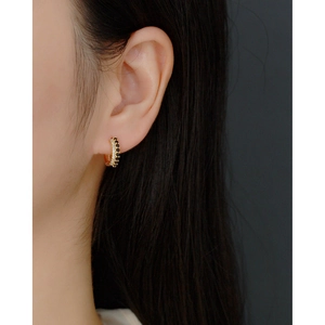 Close-up of elegant gold hoop earrings with double-row black and white zircon inlay