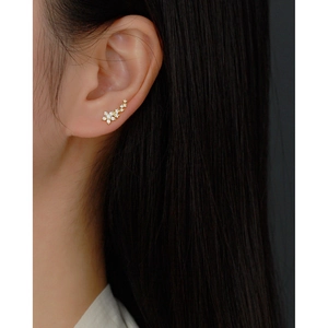 Detailed macro view of gold flower cluster earrings with sparkling micro-inlaid zircon stones