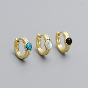 Trois boucles d'oreilles huggie dorées serties de turquoise, pierre de lune et onyx